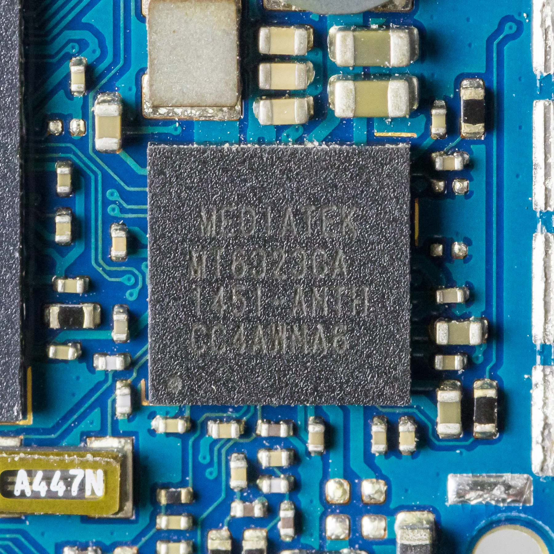 High-resolution real PCB macro showing dense surface-mount components on a blue smartphone circuit board